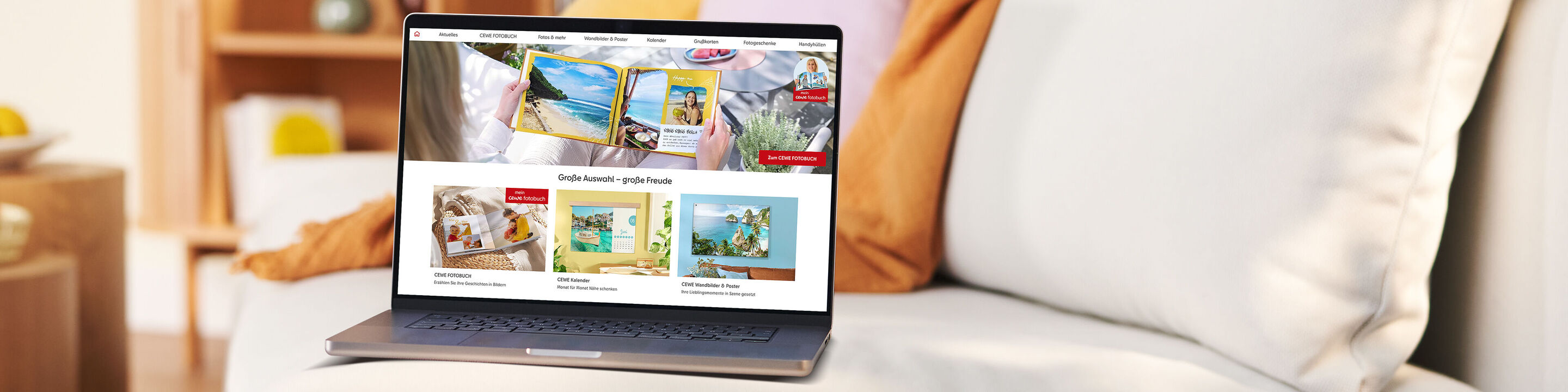 Laptop steht auf einer Couch und zeigt die Startseite der CEWE Fotowelt